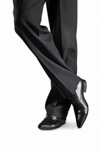 Man's feet in black trousers and black shoes